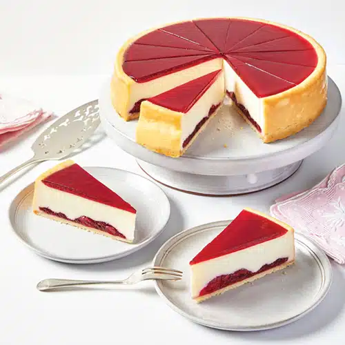A cherry cheesecake with two slices removed