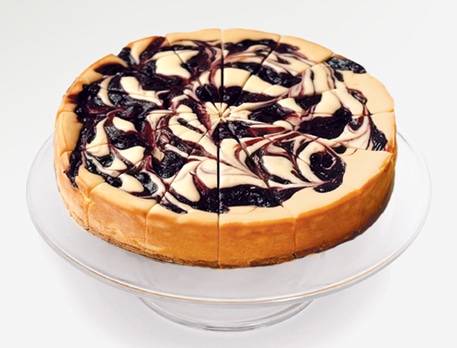 A blueberry cheesecake on a cake stand