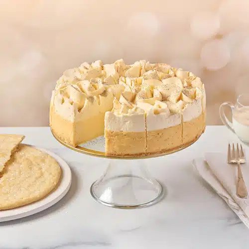 An eggnog cheesecake on a cake stand