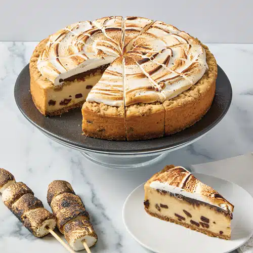 A s'mores cheesecake on a plate with a slice removed