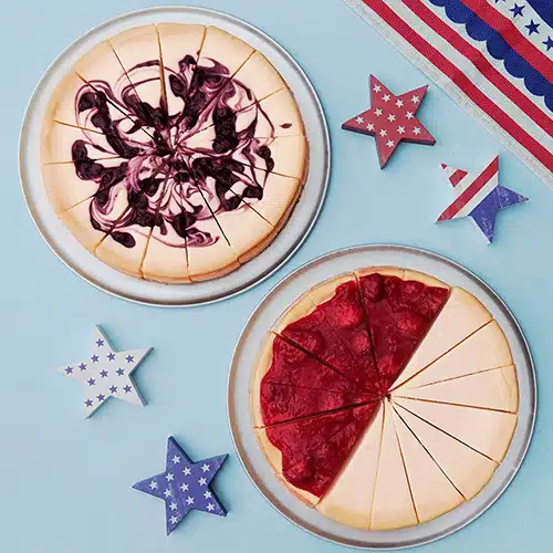A blueberry cheesecake and a half-strawberry half-plain cheesecake, with stars and stripes decorations